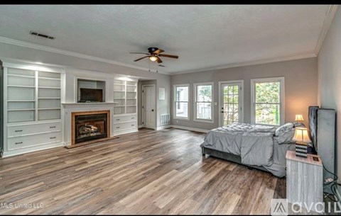 A bedroom with a fireplace and a television.