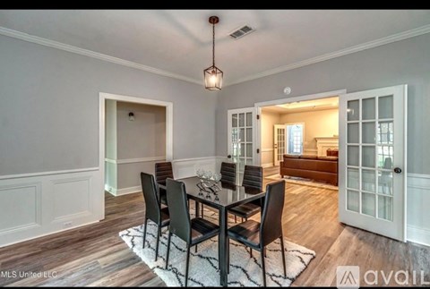 A dining room with a table set for four.