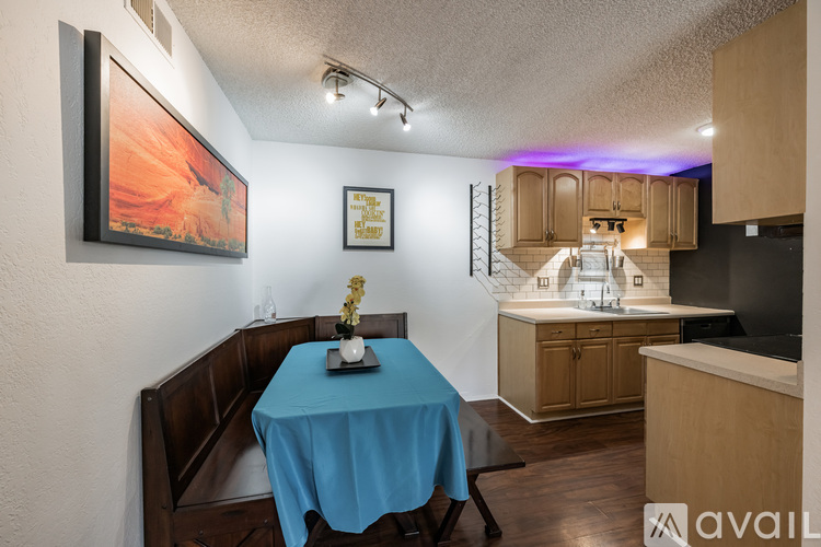 A dining room with a blue tablecloth and a painting on the wall.