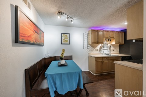 A dining room with a blue tablecloth and a painting on the wall.