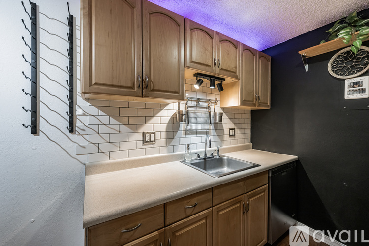 A kitchen with wooden cabinets and a black wall.