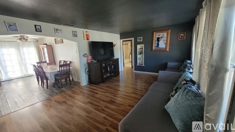A living room with a grey couch and wooden floors.
