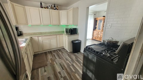 A kitchen with wooden floors and a black stove top oven.