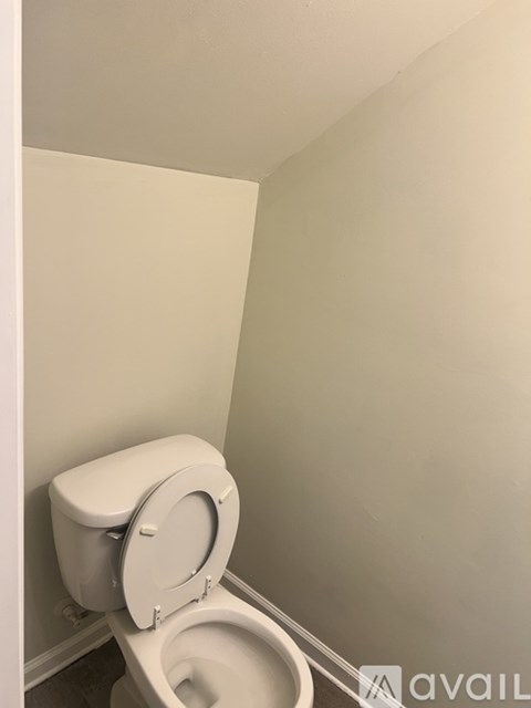 A toilet with the seat up in a bathroom.