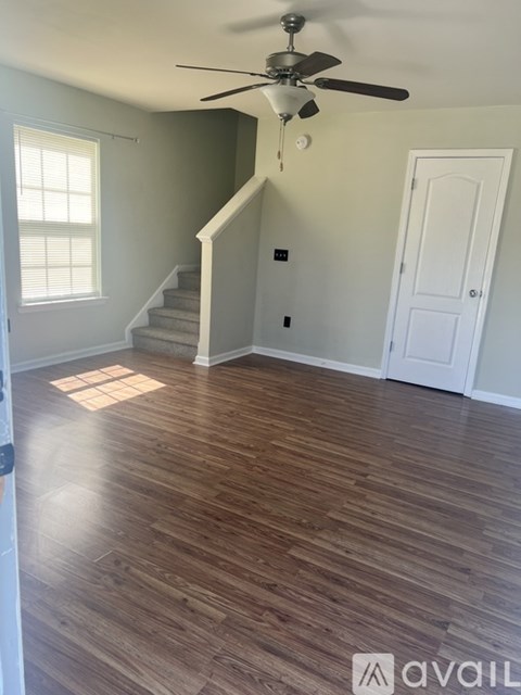 A room with wooden flooring and a staircase.