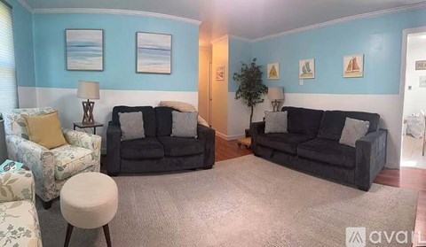 A living room with two couches and a chair.