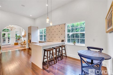 A kitchen with a white counter and a blue chair.