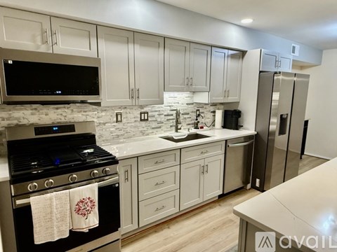 A kitchen with a black stove top oven and a white backsplash.