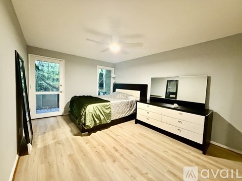 A bedroom with a bed, dresser, and window.