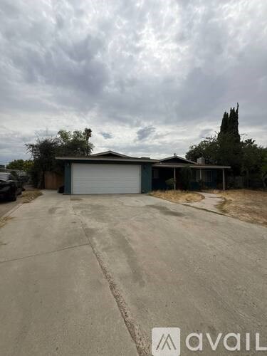 A grey house with a closed grey garage door in front of it.