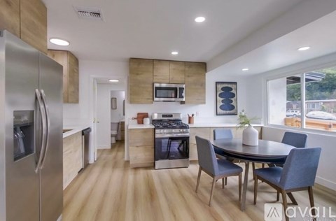 A modern kitchen with a dining table and chairs.