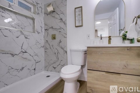 A bathroom with a marble wall and a white toilet.