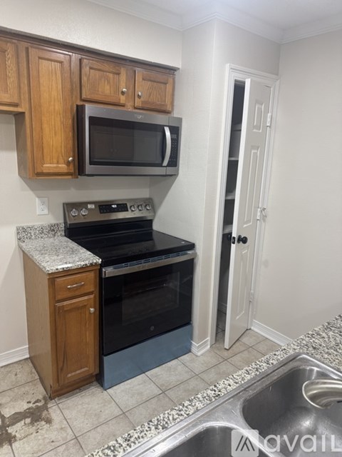A kitchen with a sink, stove, and microwave.