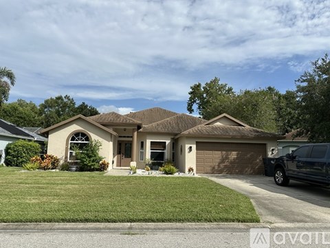 A house with a brown roof and a black car parked in front.