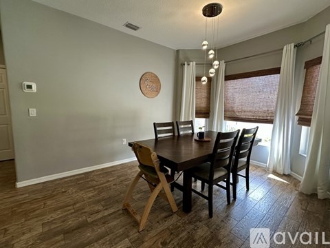A dining room with a wooden table and chairs.
