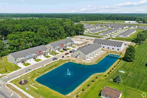 A bird's eye view of a residential area with a swimming pool and a fountain.