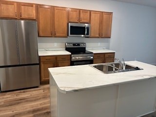 A kitchen with a stainless steel refrigerator and wooden cabinets.
