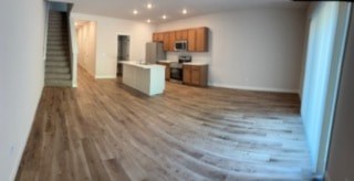A room with wooden floors and a staircase.
