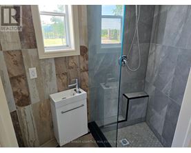 A bathroom with a glass shower stall and a white sink.