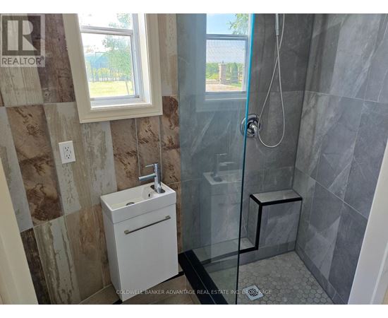 A bathroom with a glass shower stall and a white sink.