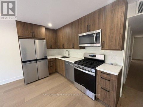 A kitchen with wooden cabinets and stainless steel appliances.