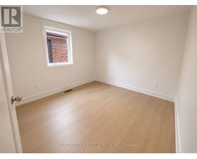 A room with a window and wooden flooring.
