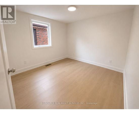 A room with a window and wooden flooring.