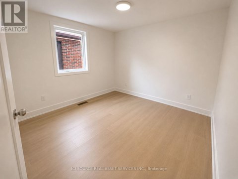 A room with a window and wooden flooring.