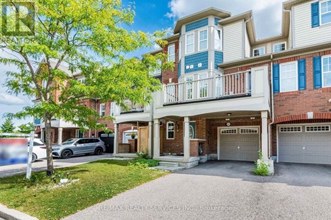 A two-story building with a balcony and a garage door.