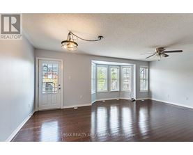 A room with a ceiling fan and a door leading to a balcony.