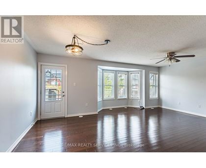 A room with a ceiling fan and a door leading to a balcony.