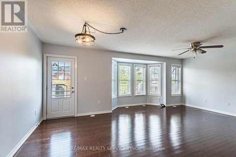 A room with a ceiling fan and a door leading to a balcony.