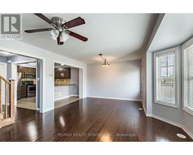 A spacious room with a ceiling fan and hardwood floors.