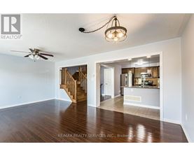 A spacious living room with a staircase leading to the upper floor.