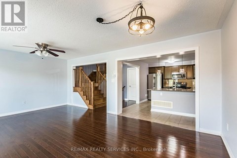 A spacious living room with a staircase leading to the upper floor.