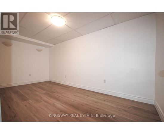Empty room with wooden floor and white walls.