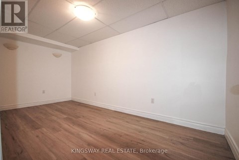 Empty room with wooden floor and white walls.
