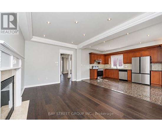 A spacious kitchen with wooden cabinets and a marble floor.