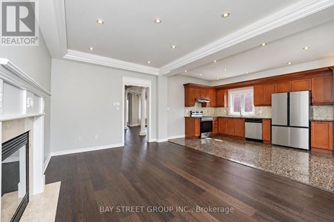A spacious kitchen with wooden cabinets and a marble floor.