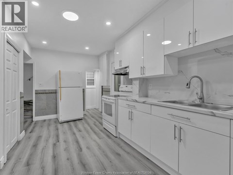 A kitchen with white cabinets and appliances.