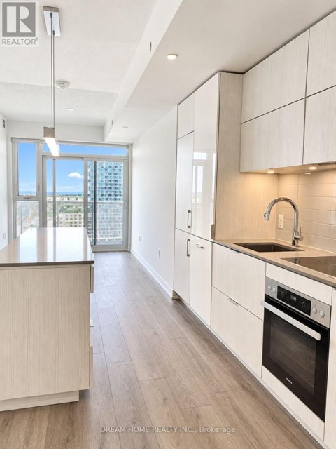 A modern kitchen with white cabinets and a wooden island.