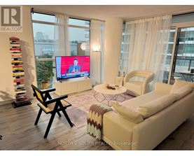 A living room with a large screen and a couch.