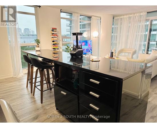A black and white kitchen with a large island and a view of the city.