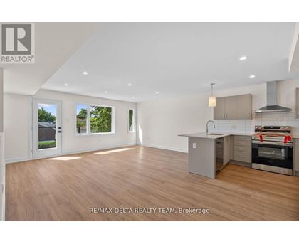 A spacious room with a kitchen area and a large window.