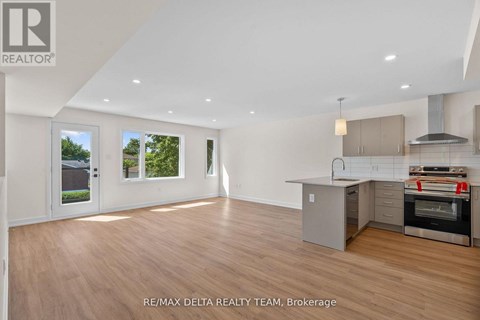 A spacious room with a kitchen area and a large window.