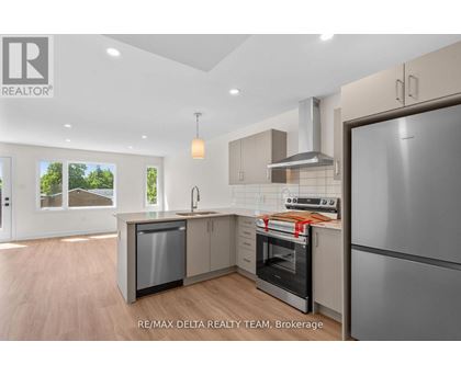 A modern kitchen with a refrigerator, oven, and sink.