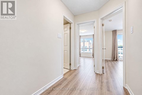 A hallway with a door on the left and a window on the right.