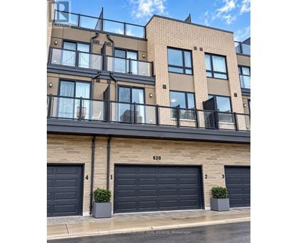 A building with the number 620 on it has three garage doors.