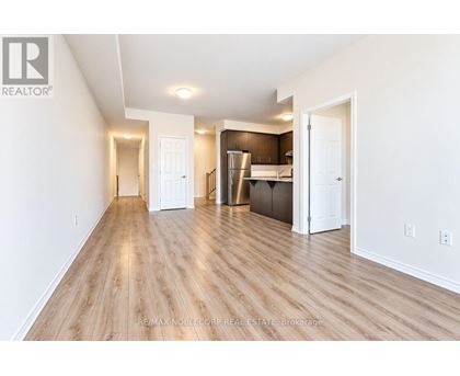 A spacious room with wooden flooring and white walls.
