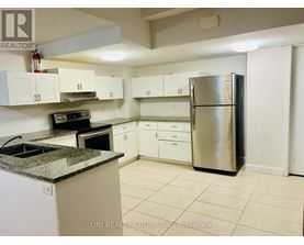 A kitchen with a refrigerator, oven, and cabinets.